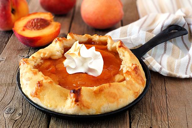 istock Peach tart with whipped cream in cast iron baking skillet 593337894