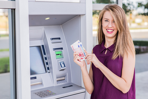 Getting the cash, Smiling Woman withdrawing cash from ATM