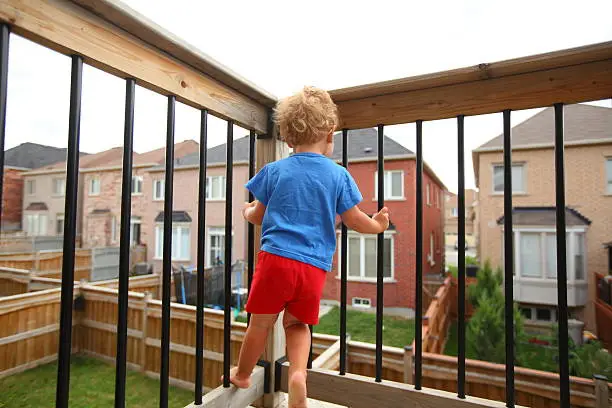 Photo of Little boy standing on the balcony