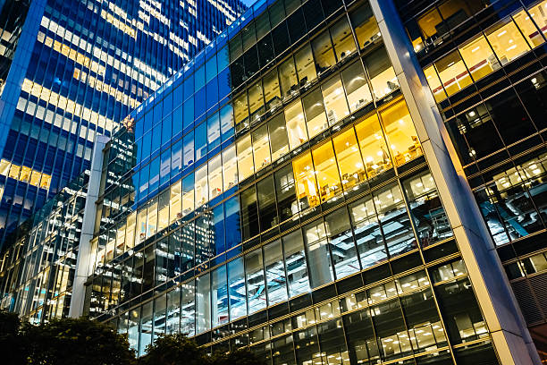 Illuminated office buildings at Canary Wharf, London at Night Illuminated modern office buildings at canary wharf in London at night. office building stock pictures, royalty-free photos & images