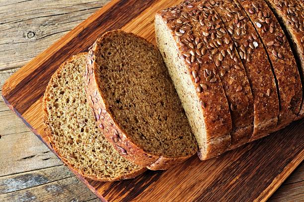 istock Sliced whole grain bread with flax, above view on wood 593340110