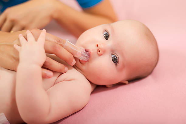 mutter reinigung baby mund mit speziellen fingerspitzenbürste - child brushing human teeth brushing teeth stock-fotos und bilder