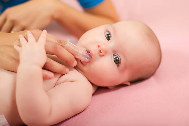 madre che pulisce la bocca del bambino con una speciale spazzola per le dita - dental hygiene human teeth toothbrush brushing teeth foto e immagini stock