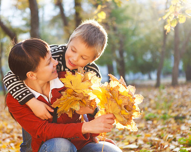 istock Mother and her son in a autumn park 594013028