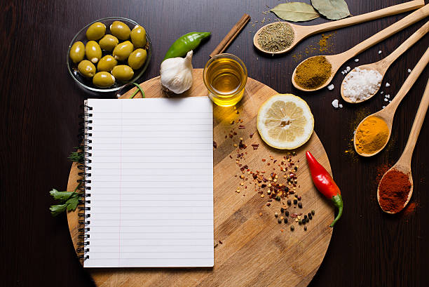 istock Recipe book on round cutting board with various spices around 594015382