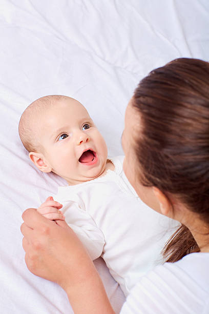 istock Mother and baby on bed. Beautiful smiling cute 594015522