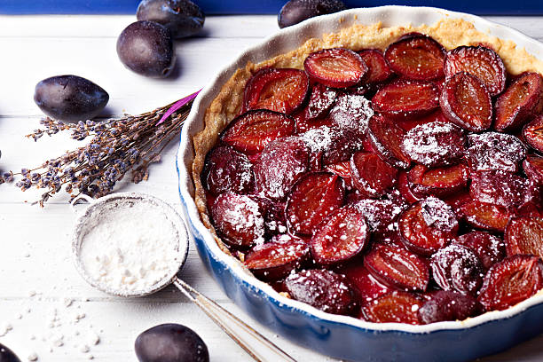istock Homemade pie with plums and sieve on the table 594016284