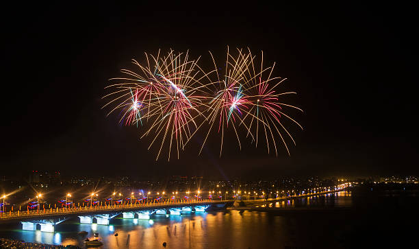istock Fireworks over the city in large river with bridge in lights 594020160