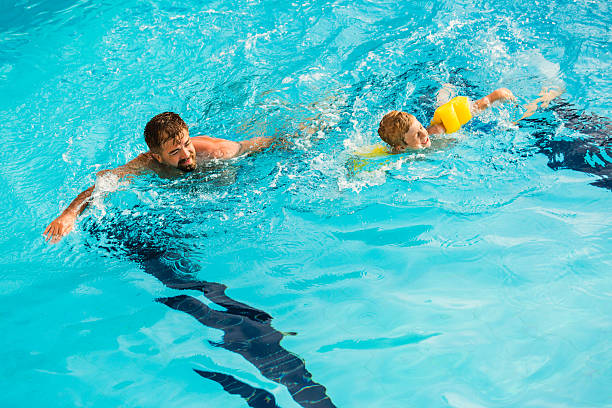 istock Father and son swimming together 594021194