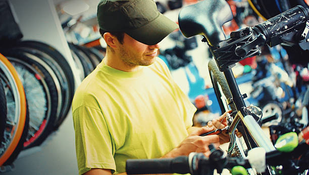 bicicleta mecânico no trabalho. - men baseball cap focus determination imagens e fotografias de stock