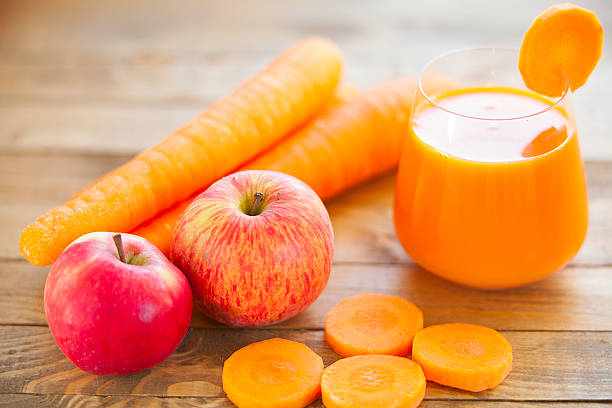 Carrot juice in glass on  table stock photo