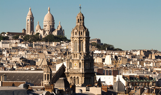 The Saint Trinity church and Sacre Coeur basilica in the background, Paris; France.