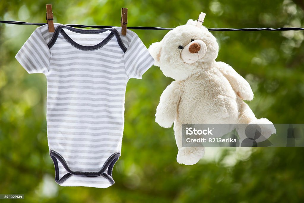 Ropa de bebé y Osito de peluche colgar en la cuerda de tender la ropa - Foto de stock de Lavar libre de derechos