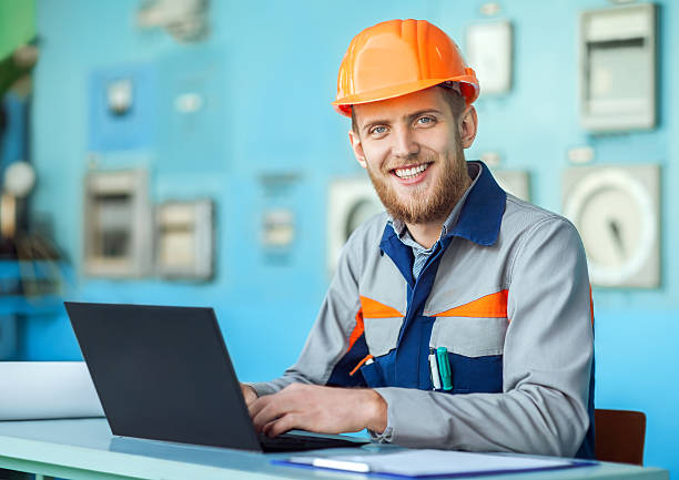 istock young happy engineer working at laptop in control room 594029600