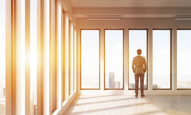 istock Businessman watching at city through panoramic windows of his of 594029962