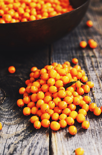 Organic sea buckthorn berries on rustic wooden background