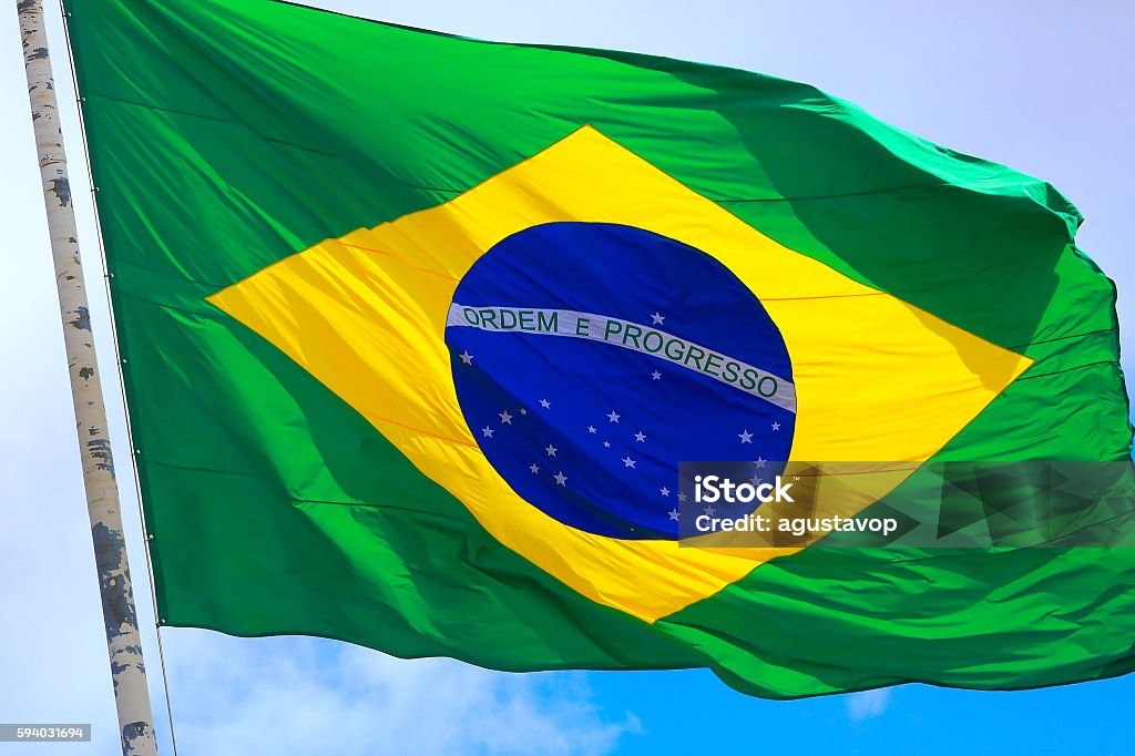 Ordem e Progresso: Colorful Brazillian Flag waving in the sky Brazilian Flag Stock Photo