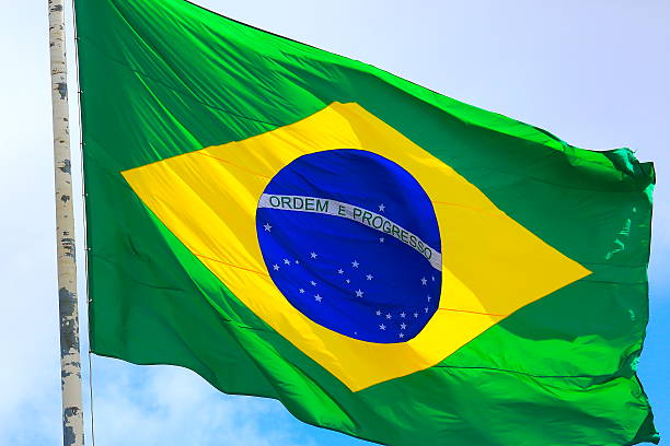 istock Ordem e Progresso: Colorful Brazillian Flag waving in the sky 594031970