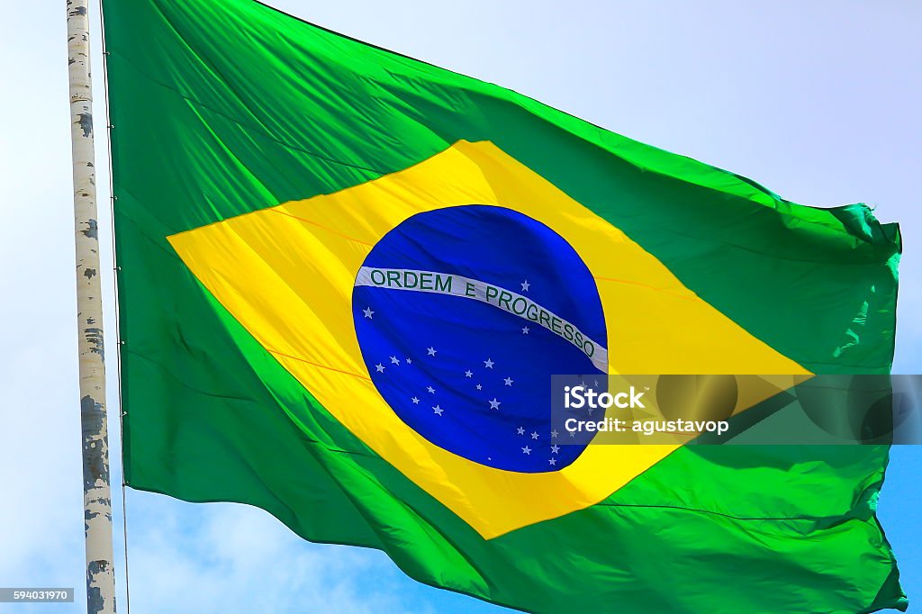 Ordem e Progresso: Colorful Brazillian Flag waving in the sky Maracanã Stadium Stock Photo