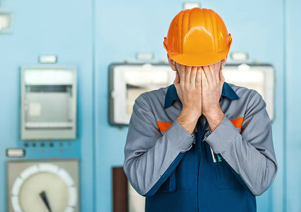 stressed engineer closed face by two hands stock photo