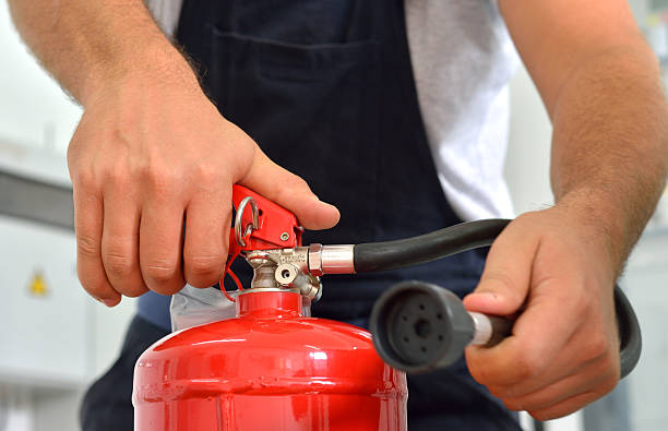Fire Extinguisher Worker demonstrates the use of fire extinguishers. fire inspection stock pictures, royalty-free photos & images