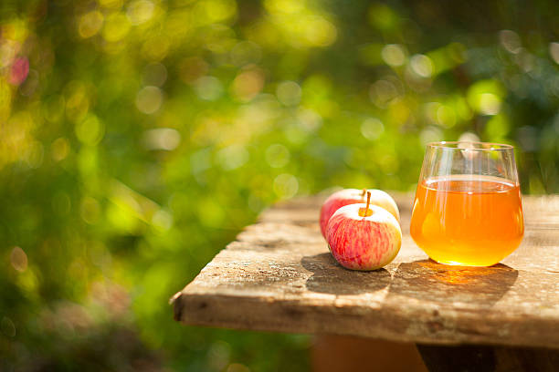 jugo de manzana de vidrio en la mesa - old plank outdoors selective focus fotografías e imágenes de stock