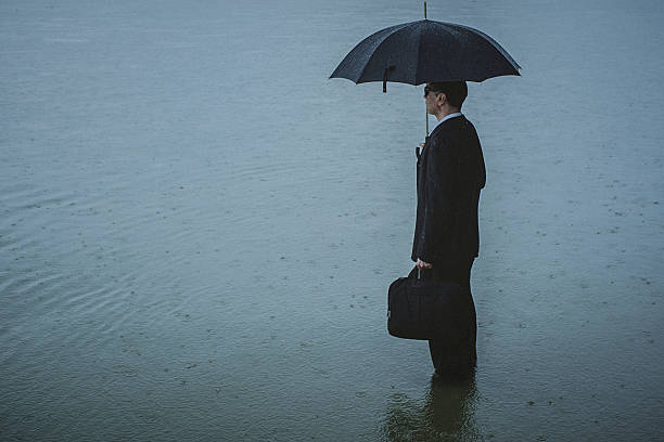 istock Handsome man wearing suit and holding umbrella during the rain 594038108
