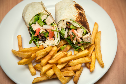 Wrap sandwiches of turkey meat and chicken, with fries.