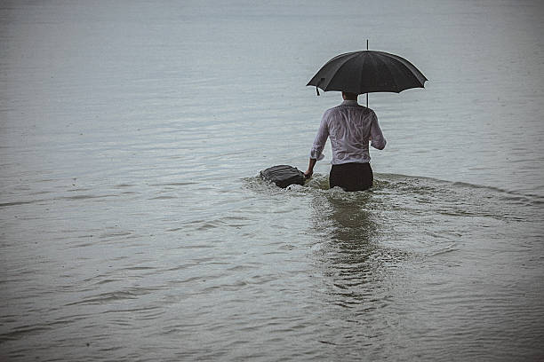 istock Handsome man wearing white shirt and holding umbrella during rain 594038954