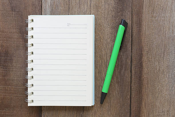 istock Notebook and pen on old wood for the design background. 594040874