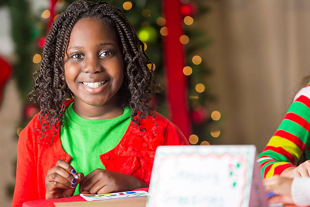 istock Smiling young girl making Christmas cards 594041954