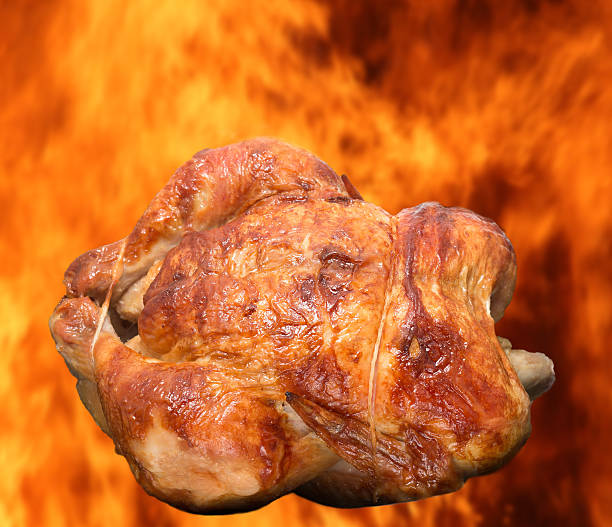 istock Roasted chicken isolated against burning flames 594043288