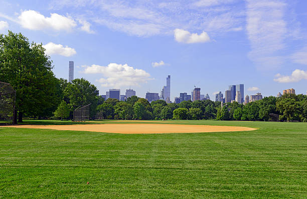 erba verde e campo da baseball di central park con manhattan - baseball field grass baseballs foto e immagini stock
