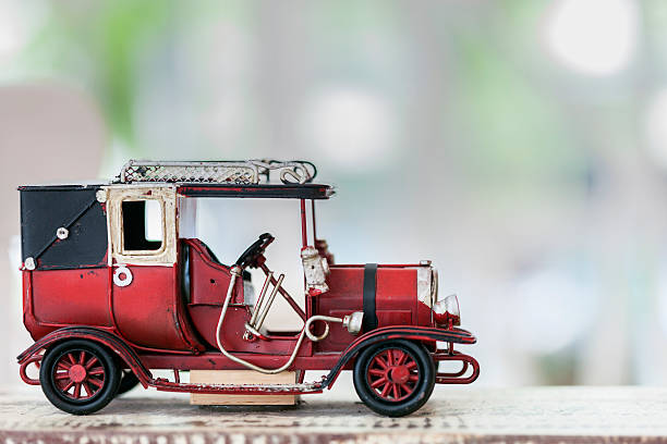 istock red vintage toy car on wooden table. 594048306