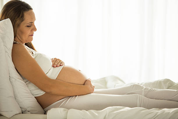 istock Pregnant woman in bed smiling 594050712
