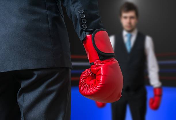 istock Businessman with red boxing gloves is boxing in ring 594051444