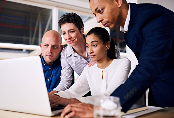 istock group of business partners looking at the same laptop screen 594054314