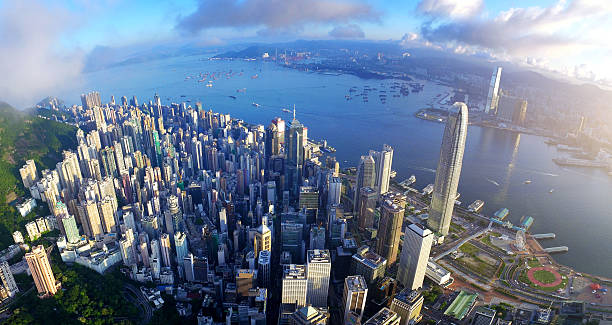 Aerial view of Victoria harbour in sunrise Dramatic skyline of Hong Kong Island and busy ships navigates across the Victoria Harbour during beautiful sunrise on a non air-polluted day. headland photos stock pictures, royalty-free photos & images