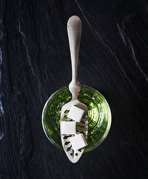 absinthe with sugar cubes and spoon flat lay composition absinthe with sugar cubes and spoon flat lay composition on top of dark slate absinthe spoon stock pictures, royalty-free photos & images
