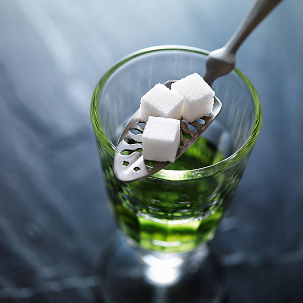 absinthe in pontarlier glass close up absinthe in pontarlier glass with spoon and sugar cubes shot close up absinthe spoon stock pictures, royalty-free photos & images