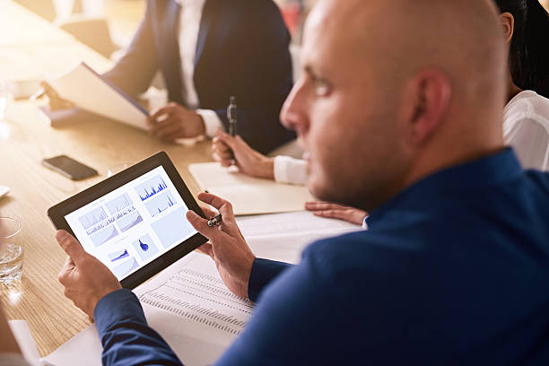 istock tablet in a business meeting with graphs on the screen 594058922
