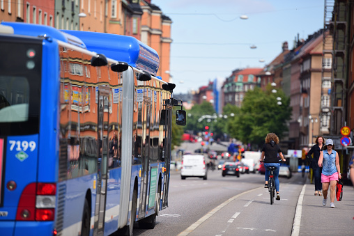 Stockholm, Sweden - August 22, 2016: Daytime picture of bus and traffic, Stockholm, Sweden. Pedestrians and bicyclists in bike lane in \