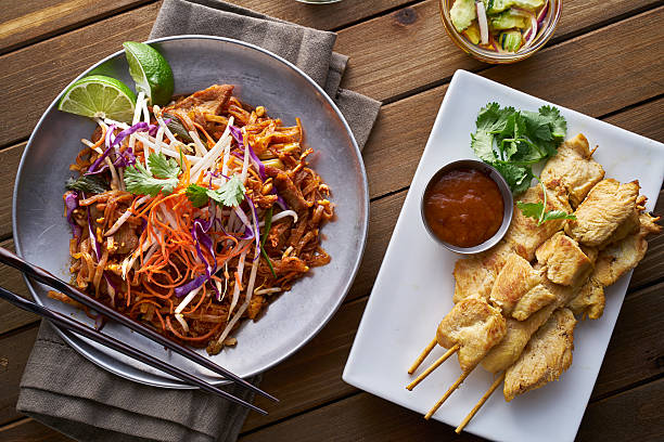 carne de res pad thai y pollo satay cena vista desde arriba - thai cuisine fotografías e imágenes de stock