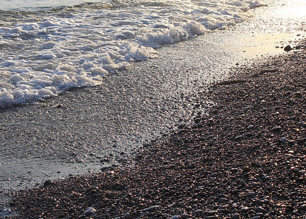 istock Evening sea beach with shingle in summer at sunset 594065360