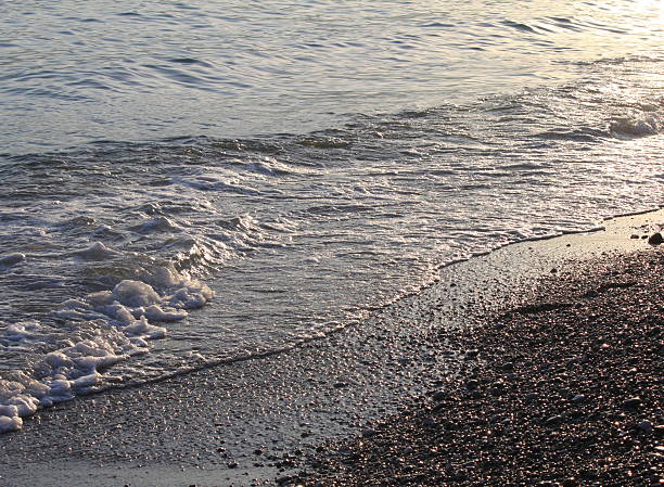 istock Evening sea beach with shingle in summer at sunset 594065920