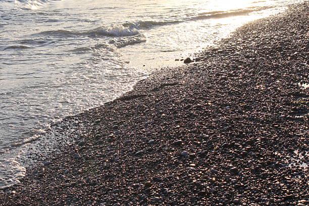 istock Evening sea beach with shingle in summer at sunset 594066116