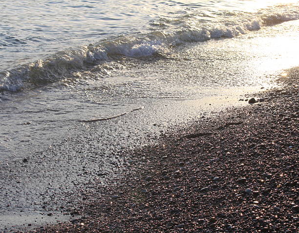 istock Evening sea beach with shingle in summer at sunset 594066568