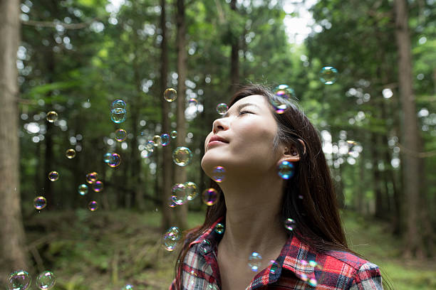Bubbles and cute girl in the forest.