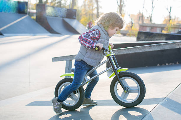 istock Little boy riding bicycle in skateboard park. 594075104