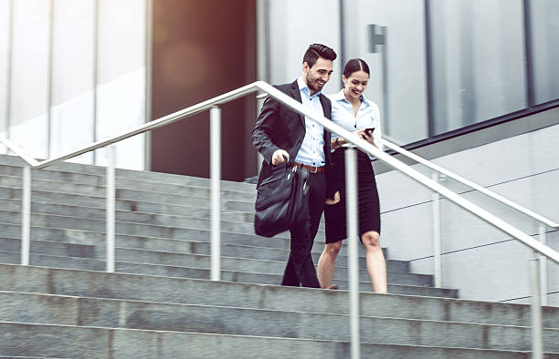 istock Business Couple Walking Down the Stairs 594075588